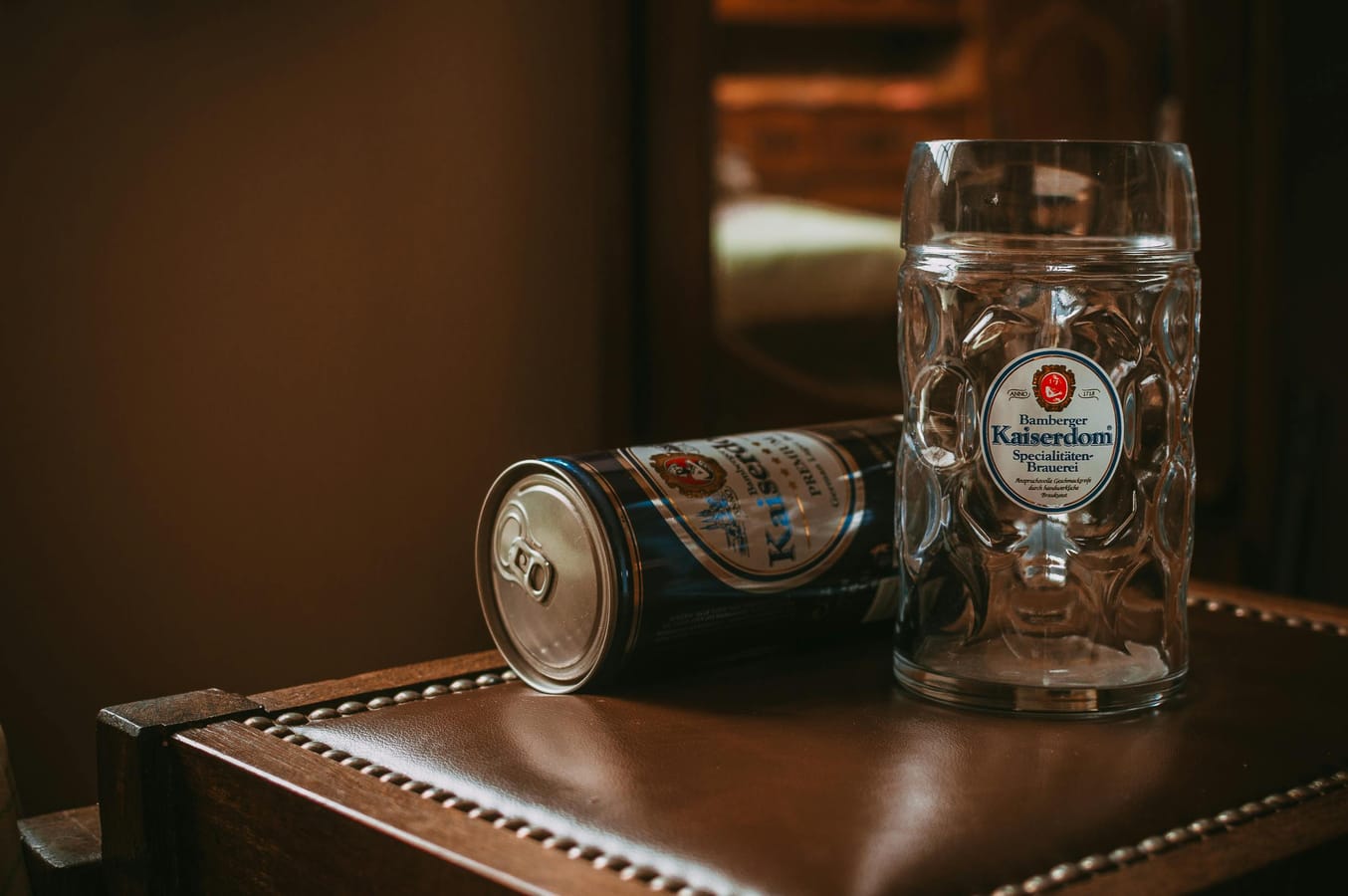 An empty pint glass and a folded gym towel on a wooden bar table in evening light.