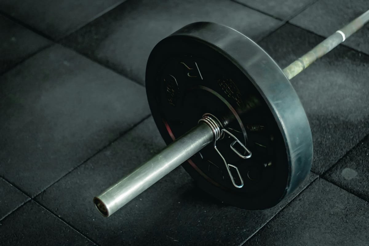 A barbell and weight plates on a gym floor.