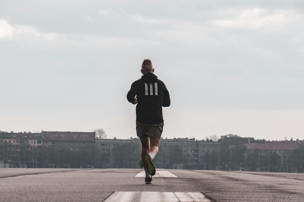 A runner on a quiet road at dawn.