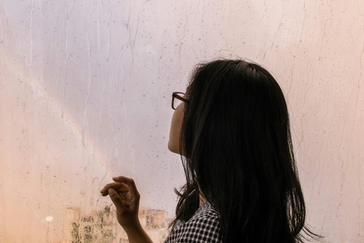 Soft light through a rainy window in a quiet interior space.