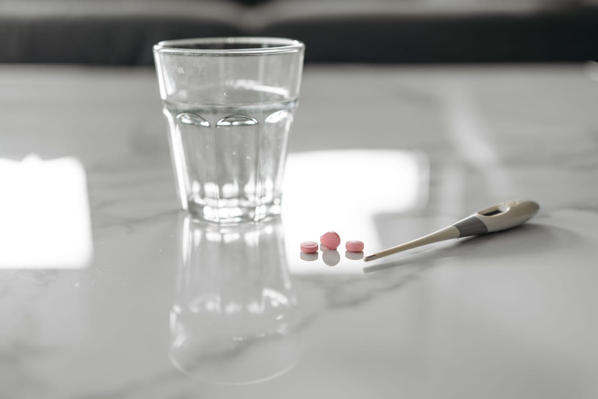 A medical illustration on a desk beside a glass of water.