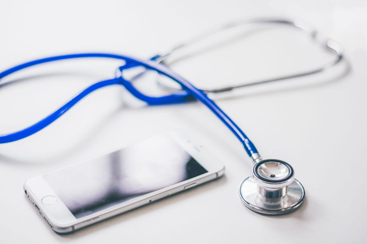 A medical examination desk with a stethoscope and tablet.