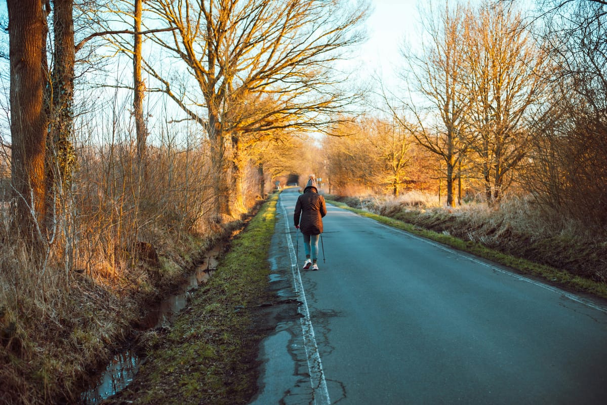 A person walking outdoors in soft morning light.
