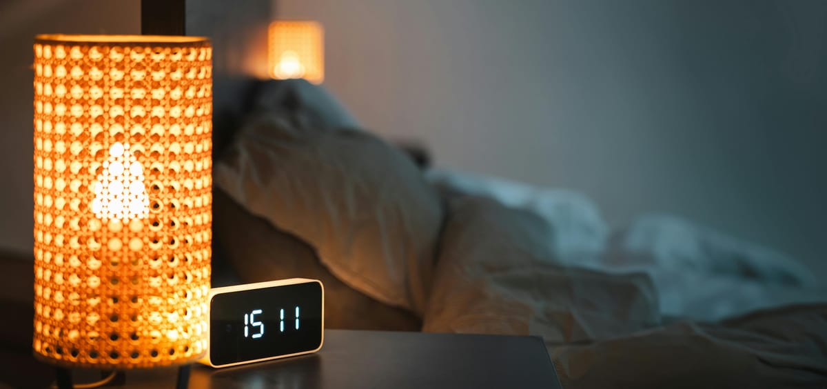 A bedside clock in dim evening light.
