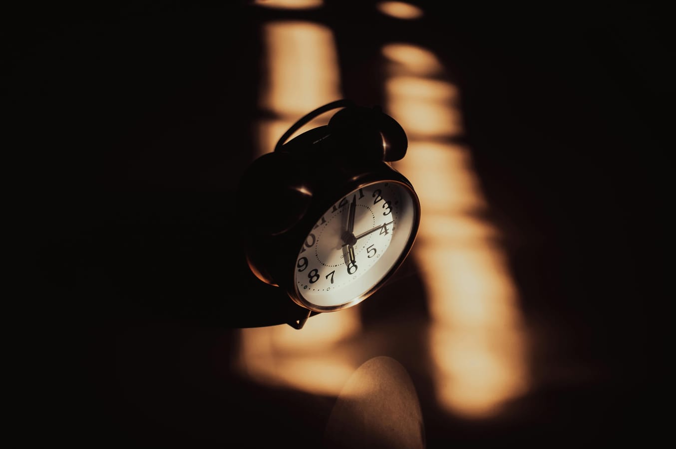 A bedside clock showing 3am with the bedroom in dim pre-dawn darkness.
