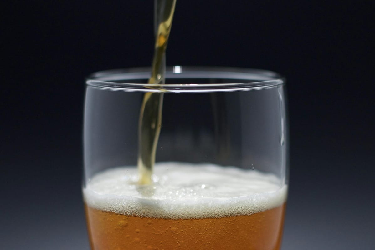 A beer being poured into a pint glass.