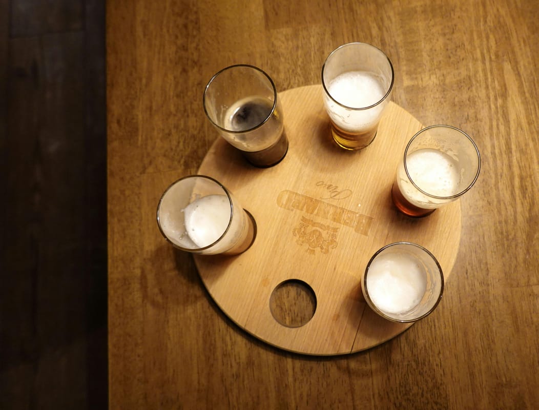 An empty pint glass on a wooden bar table.