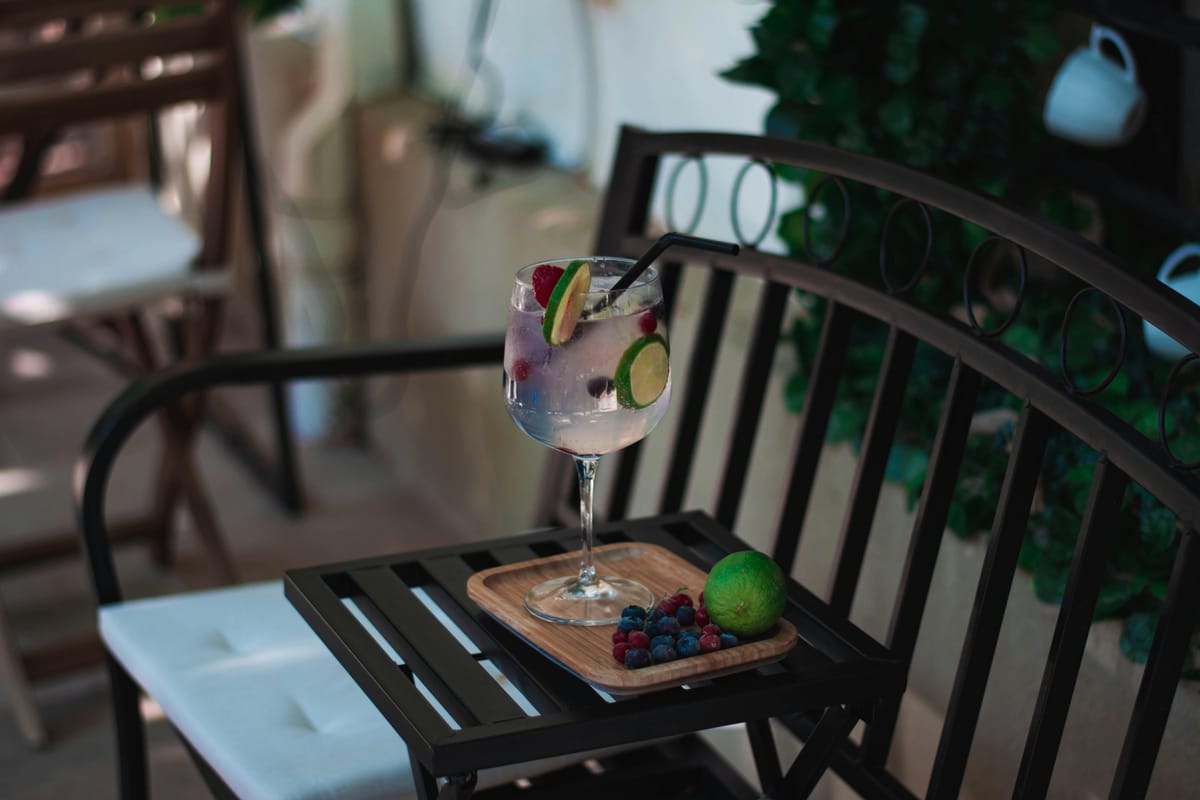 A gin and tonic with lime on a wooden bar.