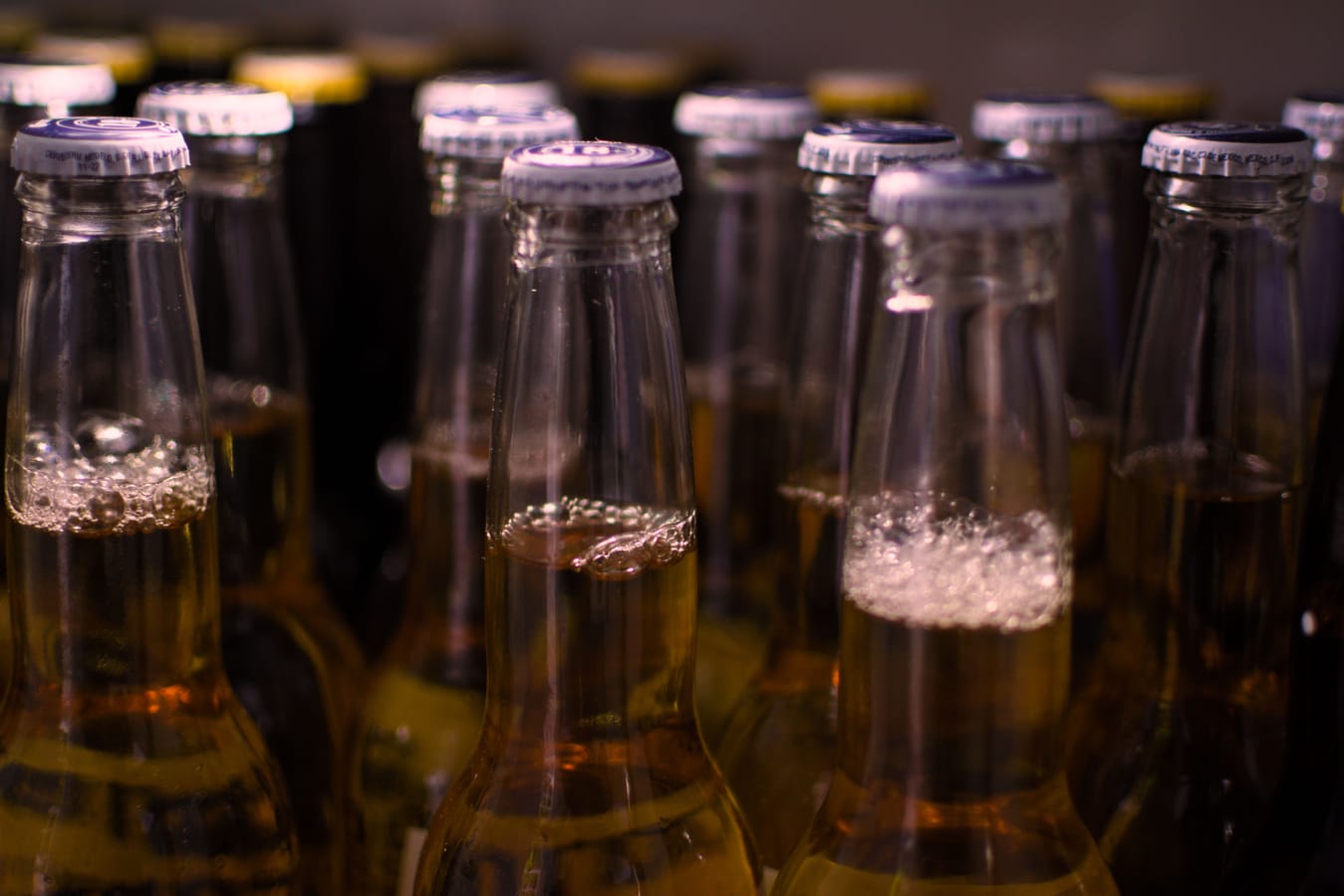 Ein kaltes Glas Bier mit Kondenswasser auf einer Theke, aus der Nähe in warmem Licht fotografiert.