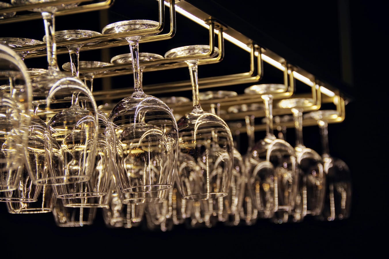 A row of empty wine glasses on a kitchen counter in soft morning light.