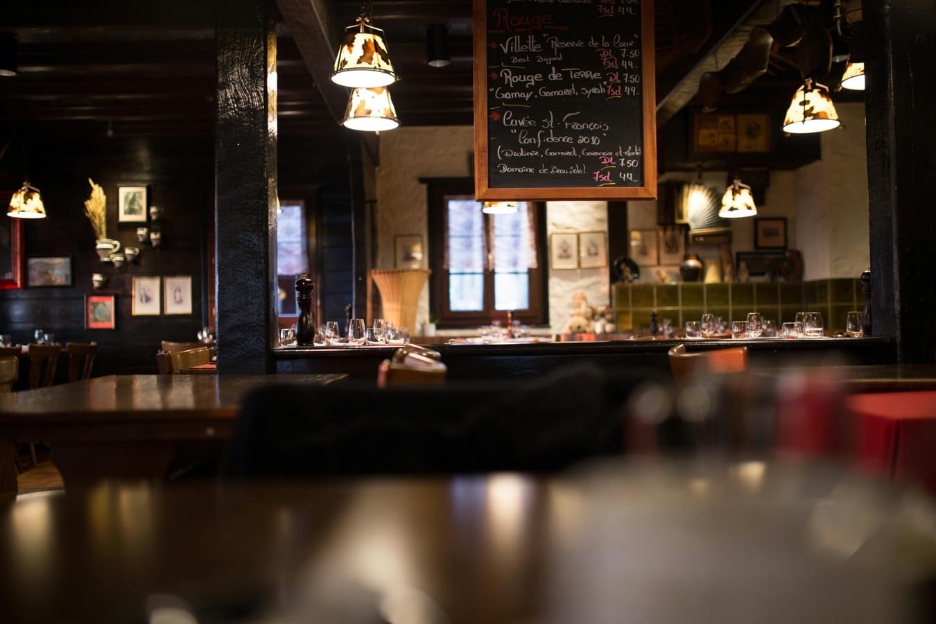 An empty wooden table outside a pub at dusk, suggesting the end of a weekend session.
