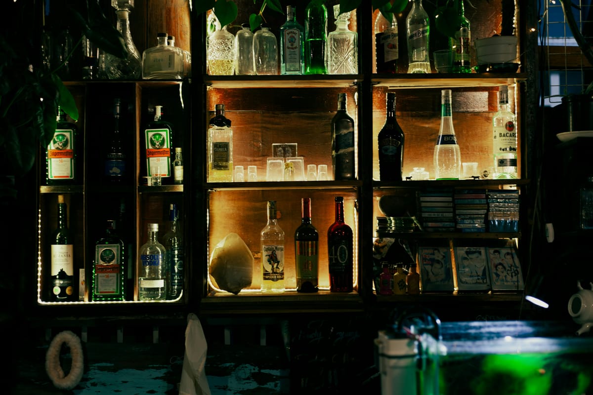 Two glasses of different sizes on a wooden bar.