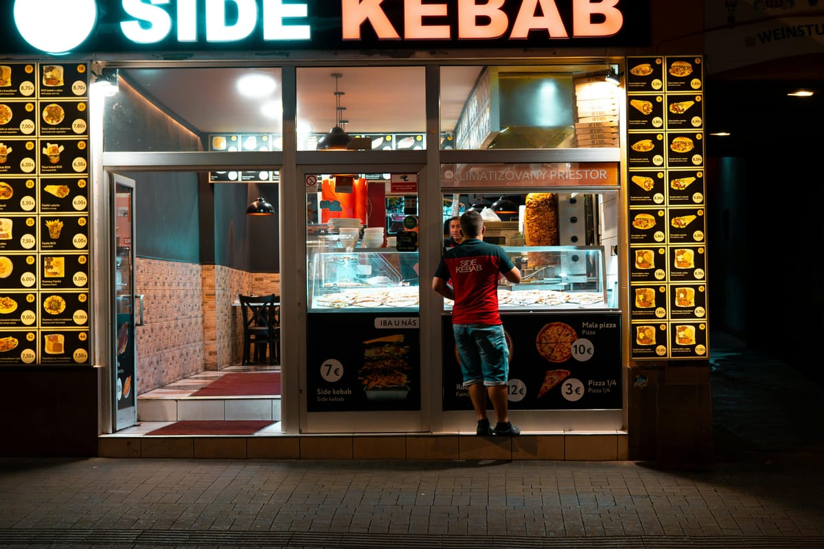 A late-night street scene with a food shop.