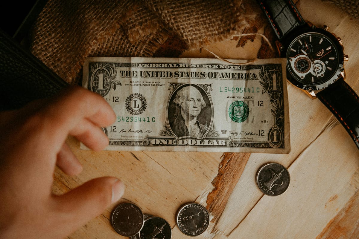 Coins and notes on a wooden bar surface.