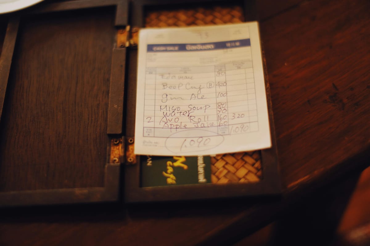 A receipt on a wooden bar table.