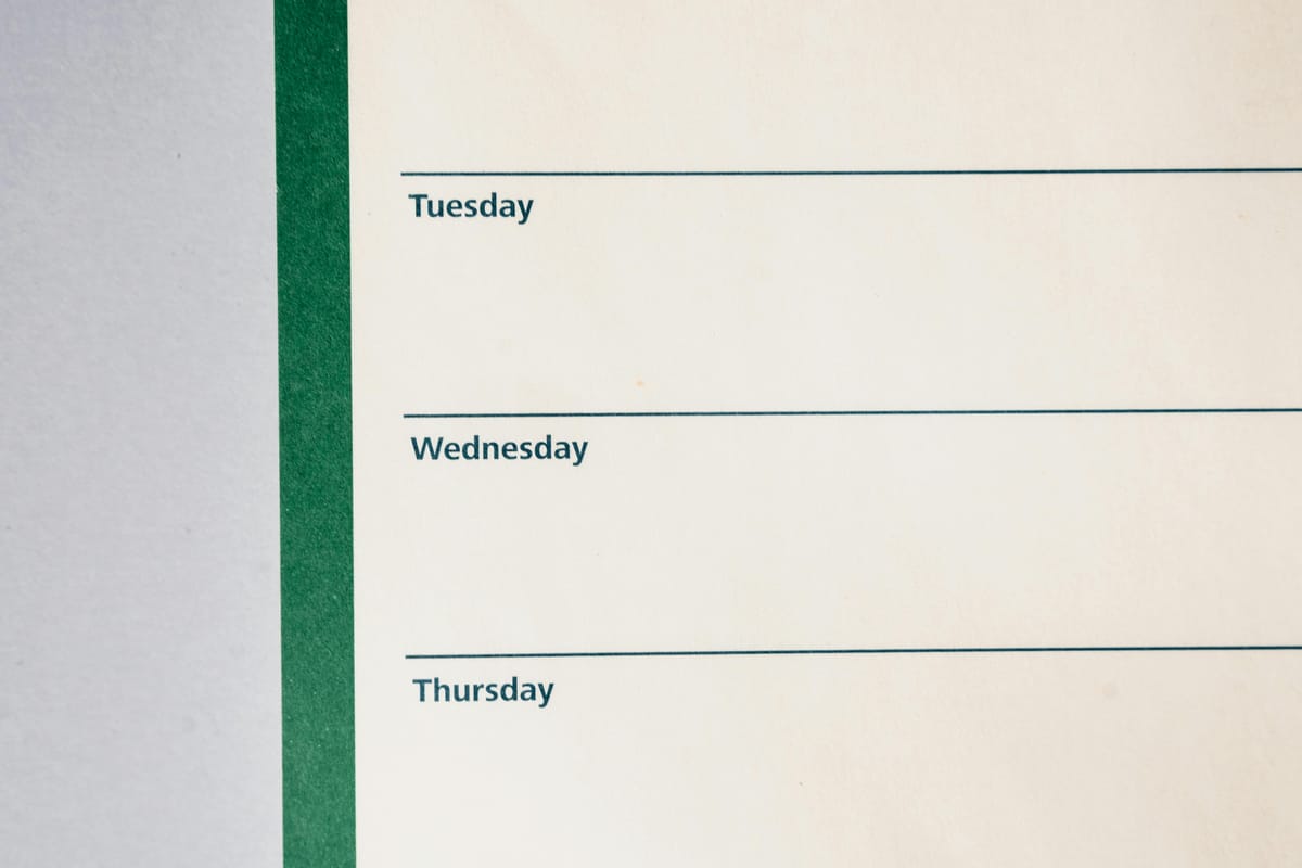 A weekly calendar on a wooden desk.