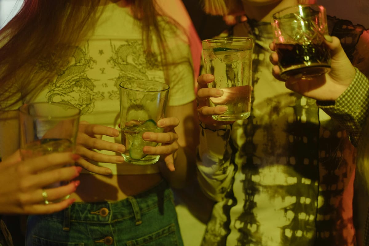 Freunde an einem Tisch mit einer Mischung aus alkoholischen und alkoholfreien Getränken.