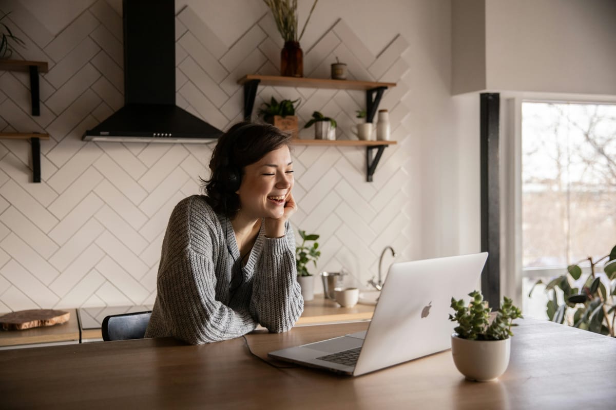 A laptop open to a video call on a kitchen table.