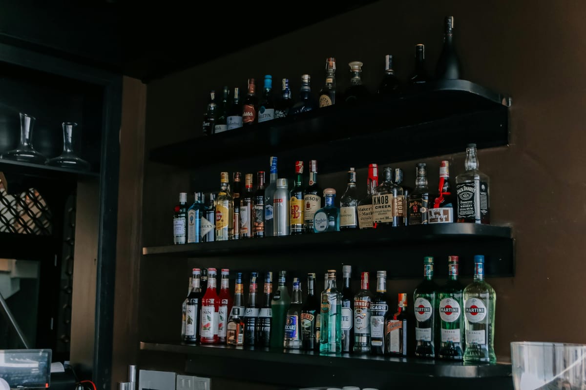 A row of spirit bottles on a wooden shelf.