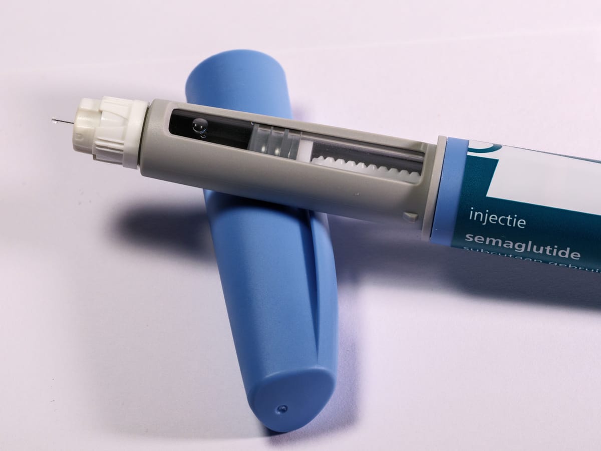 An injection pen with a visible dose dial on a plain surface.