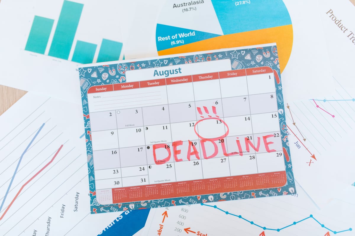 A weekly planner with marked days on a desk.