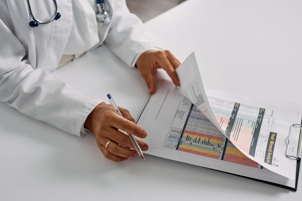 A person reviewing printed charts and documents at a desk.