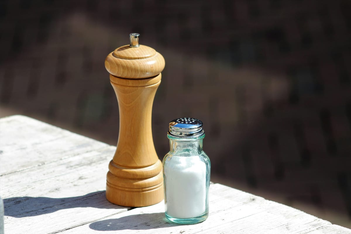 Salt and a glass of water on a wooden surface.