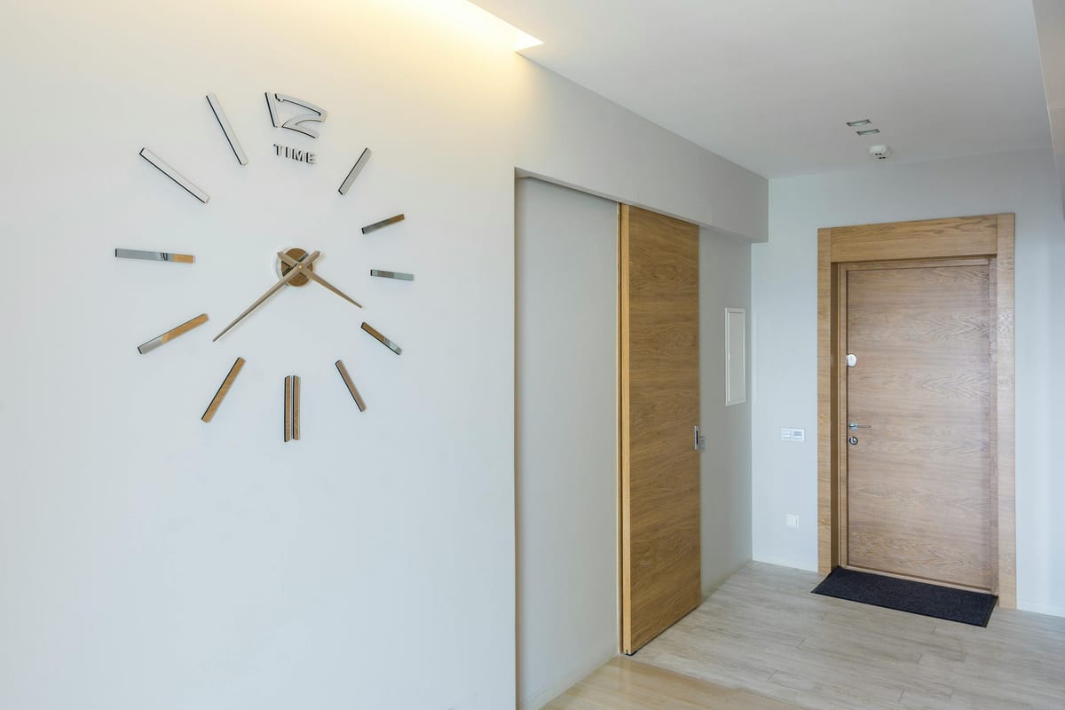 A simple clock on a kitchen wall.