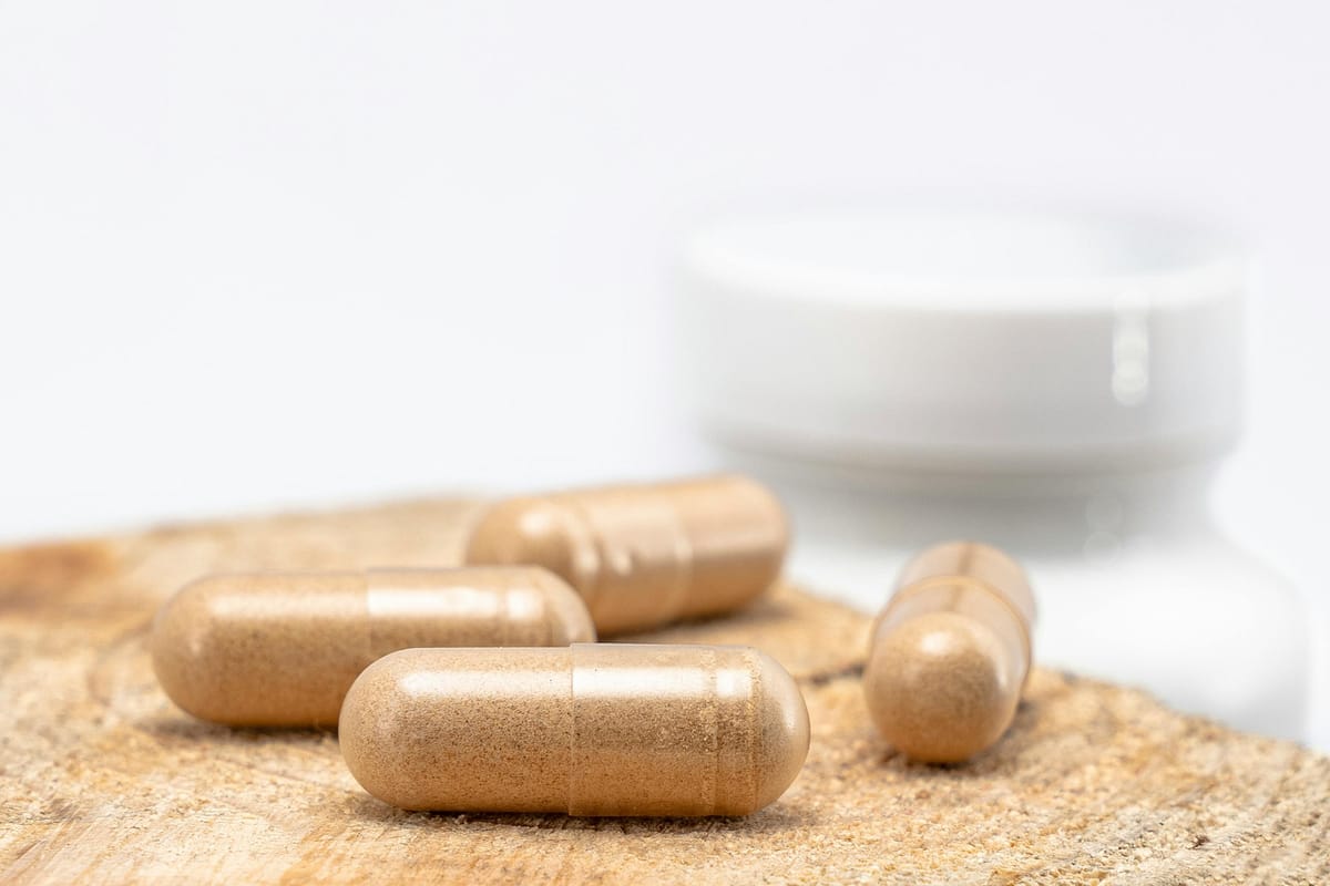 Various supplement capsules and bottles on a wooden table.