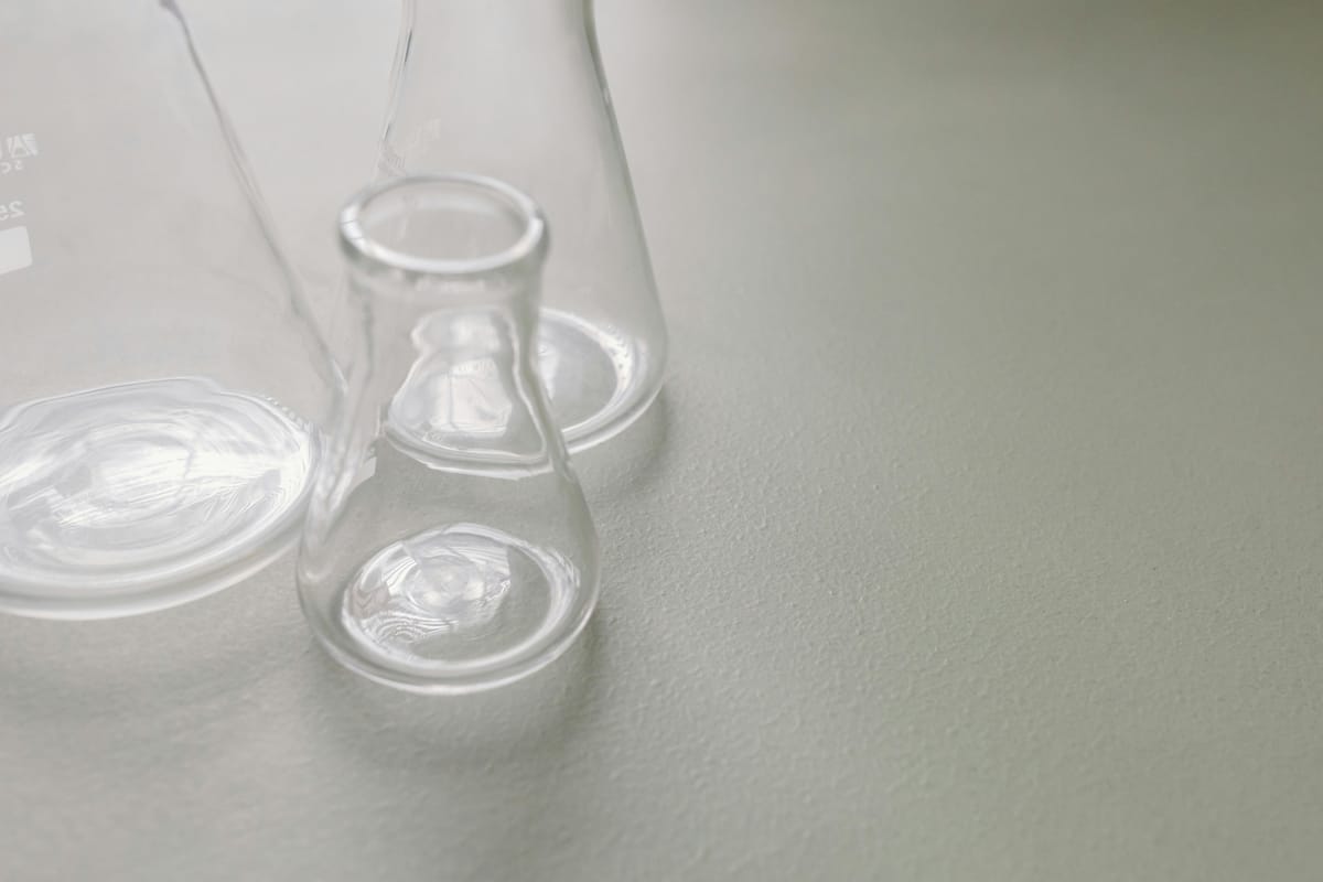 Laboratory glassware on a wooden surface, suggesting biochemistry.