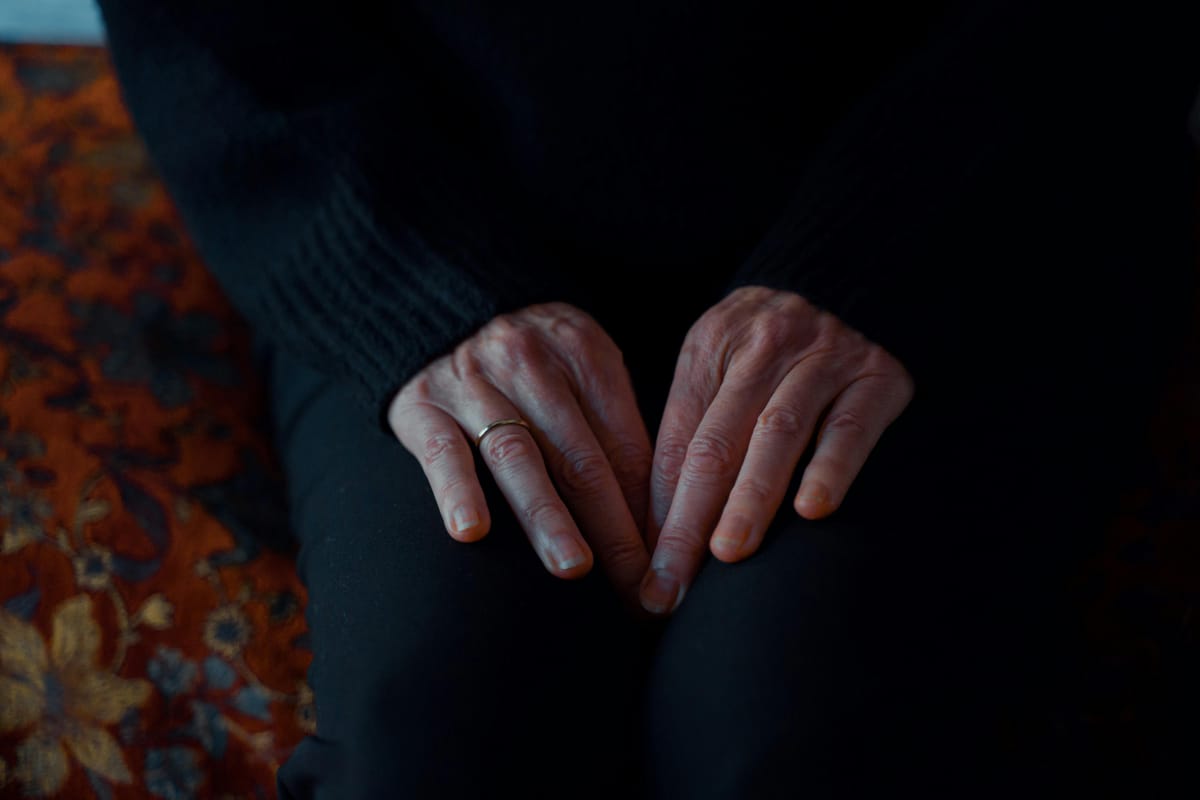Hands resting on a lap in soft natural light, suggesting calm and recovery.