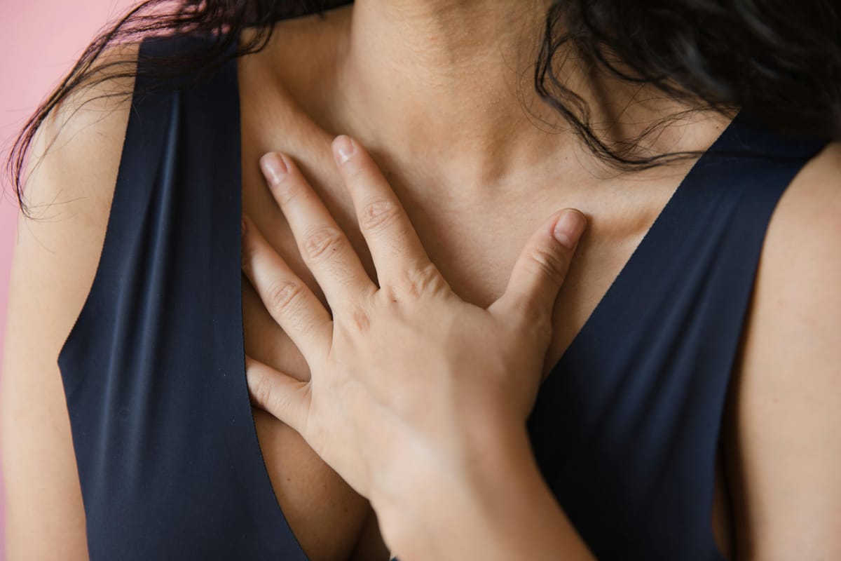 A hand resting on the chest in a gesture of self-compassion.