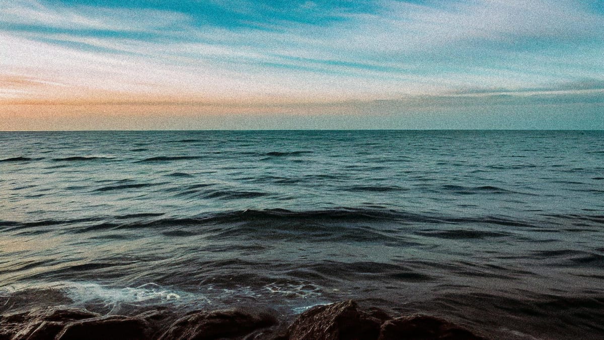 A view of the horizon over calm water in evening light.