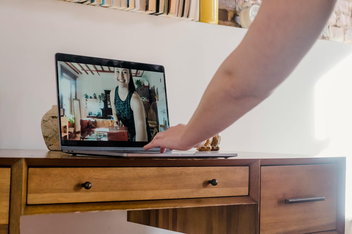 A laptop on a desk in a home office, suggesting a telemedicine appointment.