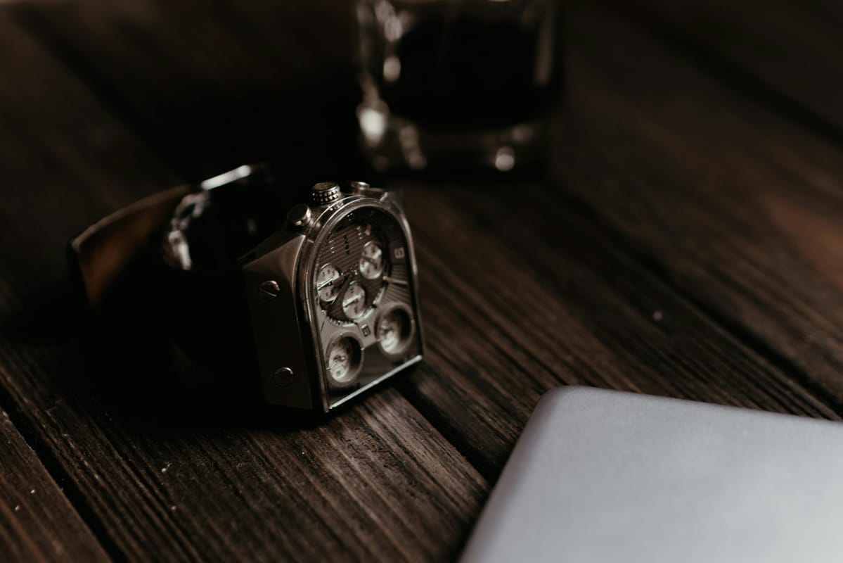 A wristwatch on a wooden table, suggesting careful timing of medication.