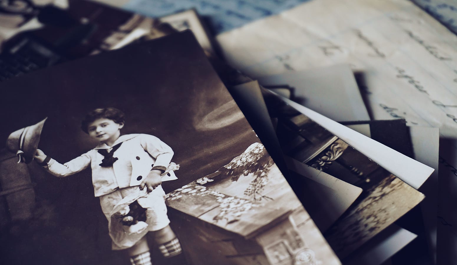 De vieilles photos de famille et des lettres manuscrites en pile désordonnée.