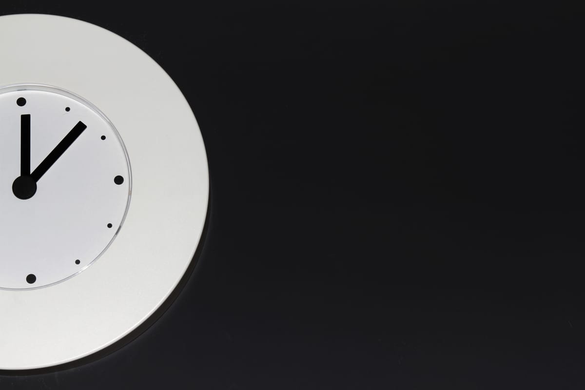 Une horloge blanche toute simple sur un fond sombre.