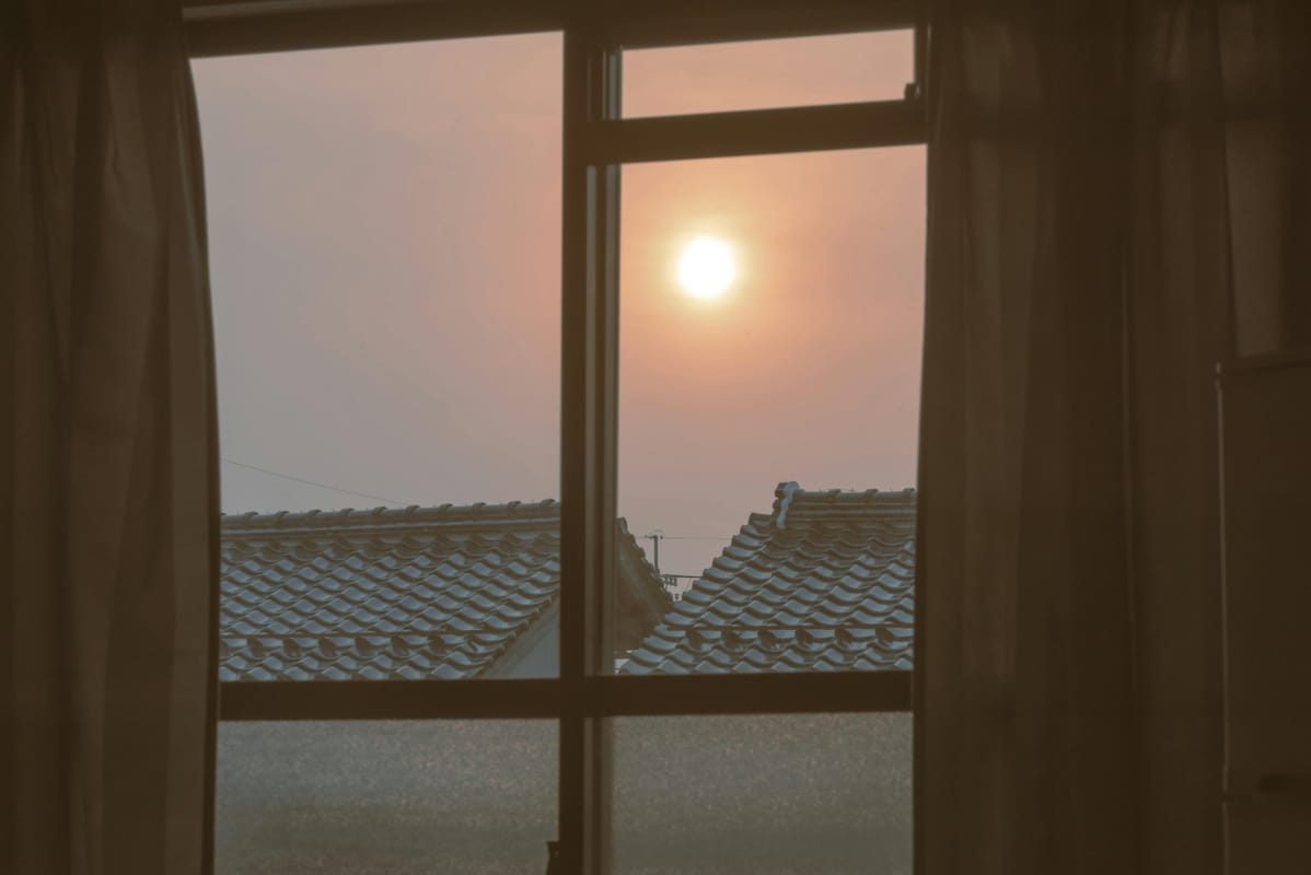 Soft sunrise light filtering through a window curtain, suggesting a new day after a difficult night.