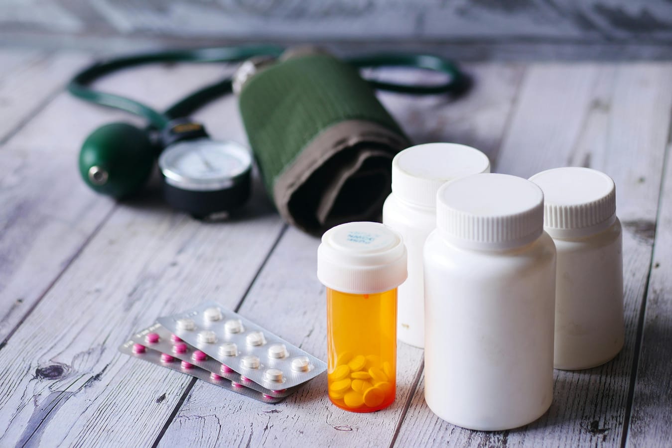 Three small bottles of medication on a wooden surface in soft natural light, suggesting a comparison.