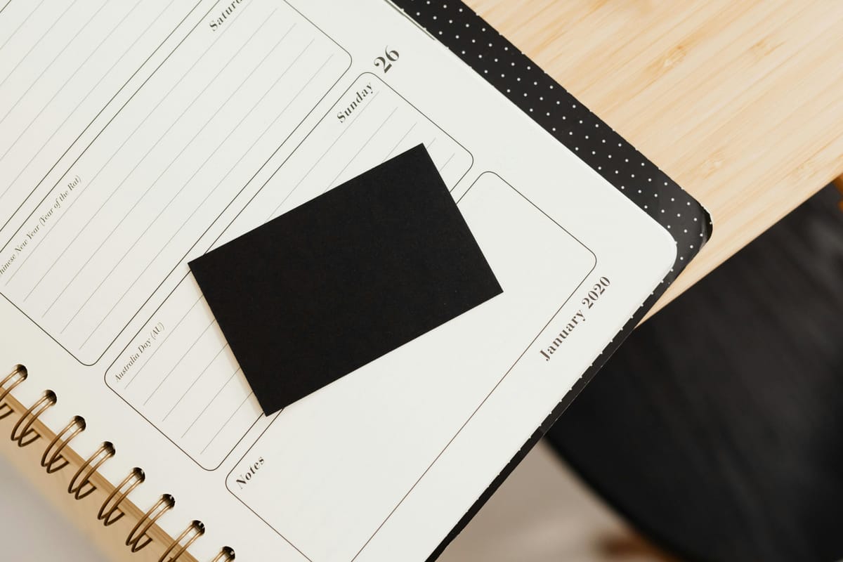 A blank monthly calendar laid out on a wooden desk, suggesting tracking progress over months.