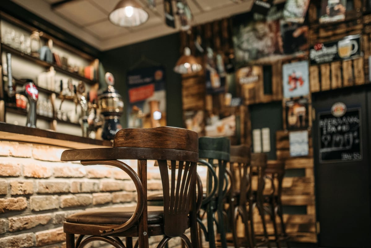 A pub interior with wooden bar and warm evening light, suggesting a calm drinking session.