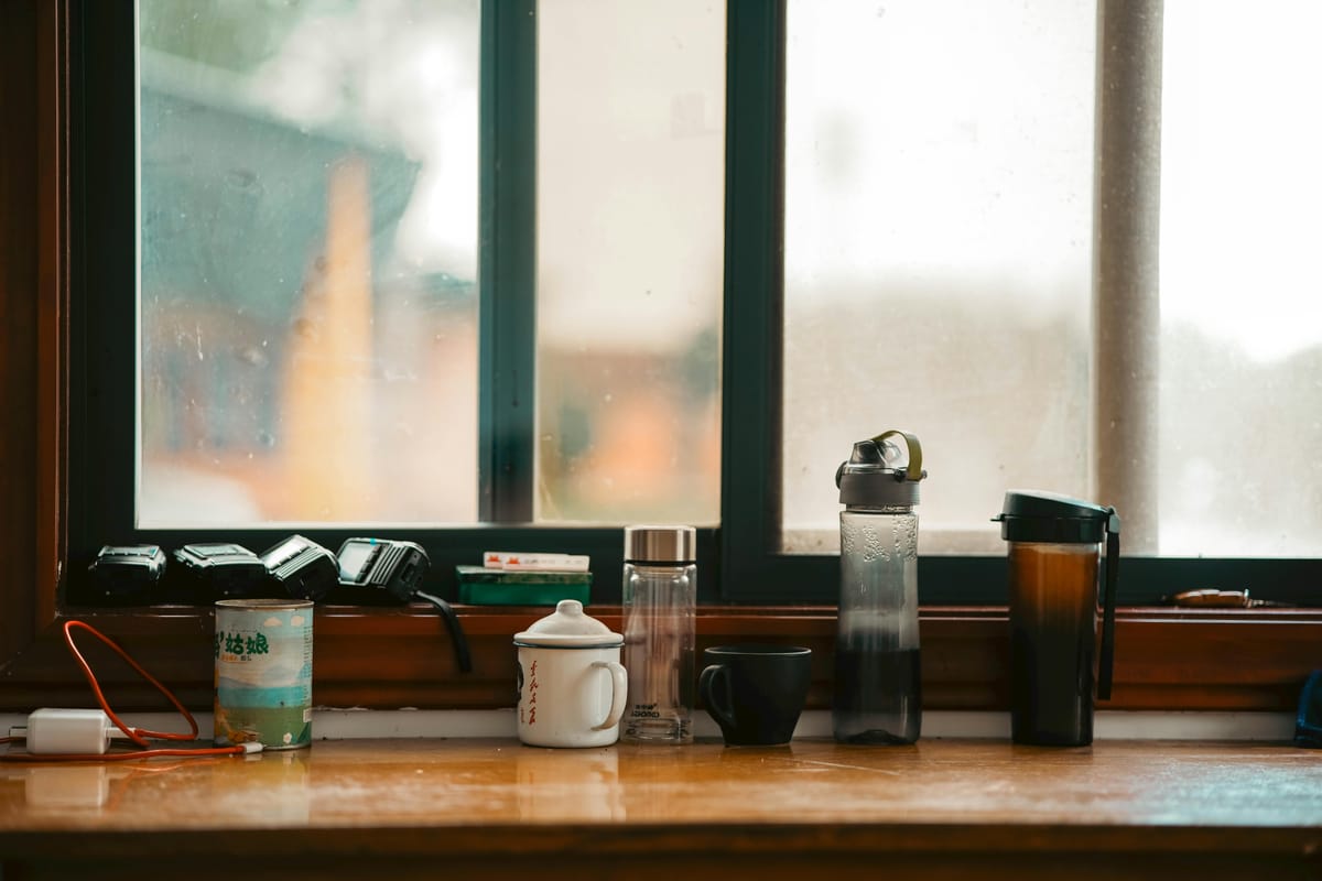 A glass of water on a windowsill at dawn.
