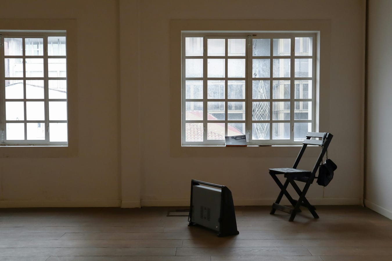 Two empty chairs facing each other in a community room with natural light, suggesting a choice between options.