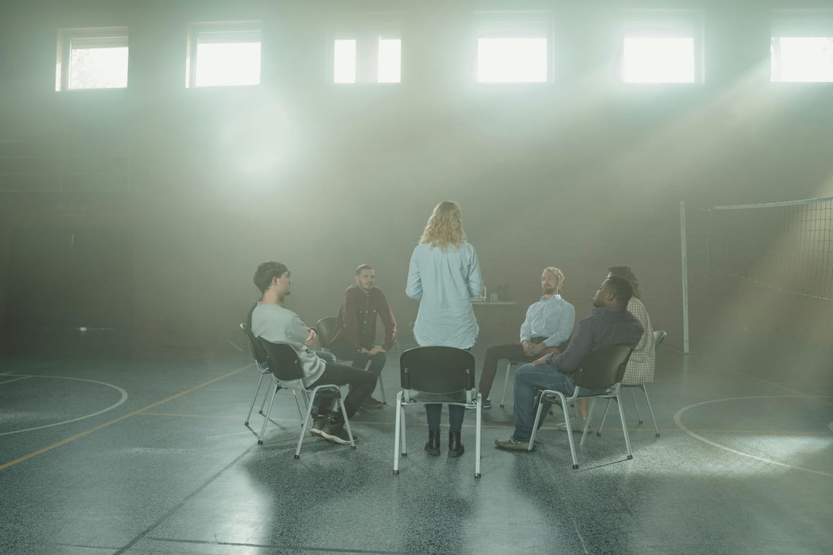 A group of people in a community room with daylight.