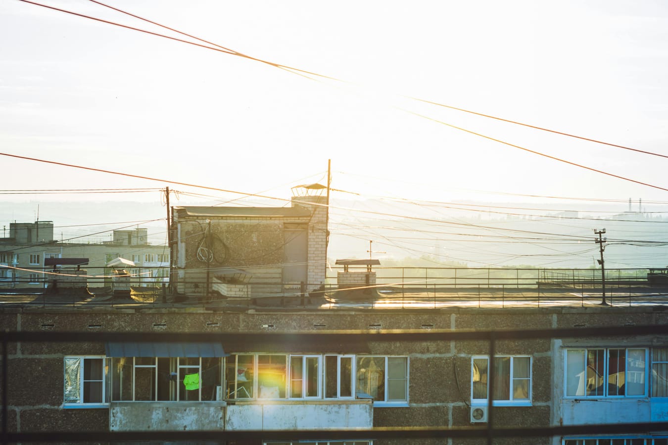 A morning view from a window with sunrise light over rooftops, suggesting fresh starts.